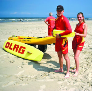 Die Rettungsschwimmer Tjard Goßling und Anna Onuseit veranschaulichen das Anbringen des Gurtretters, der als Auftriebshilfe fungiert.