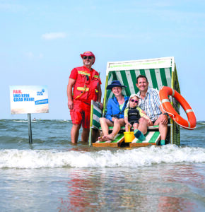 Zeichen setzen: DLRG-Wachleiter Olaf Gedrowitz (li.) und David Katzera vom „Wattenhuus“ Bensersiel mit seiner Familie. Foto: Deff Westerkamp